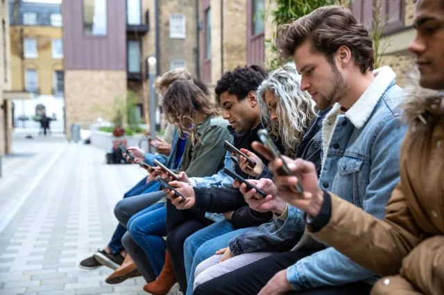 Group of teenage friend focused on their own smartphone texting on social media