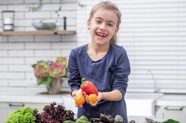 cute-little-girl-is-holding-fresh-vegetable-while-preparing-salad-copy-space (1)