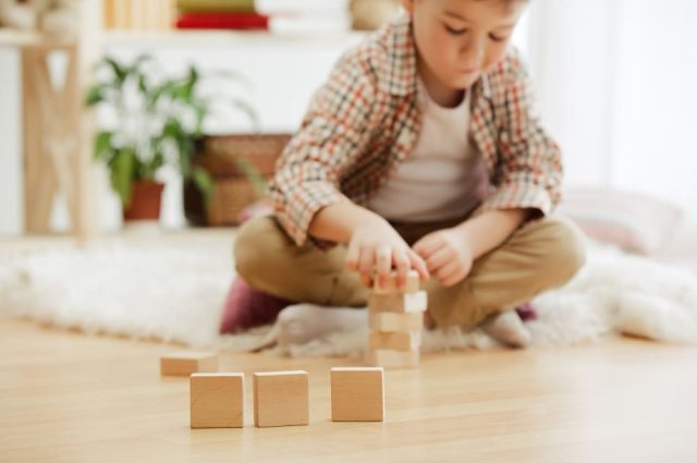 little-child-sitting-on-the-floor-pretty-boy-palying-with-wooden-cubes-at-home-conceptual-image-with-copy-or-negative-space-and-mock-up-for-your-text (1)