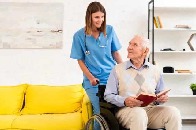 old-man-sitting-on-wheelchair-while-talking-to-nurse (1)