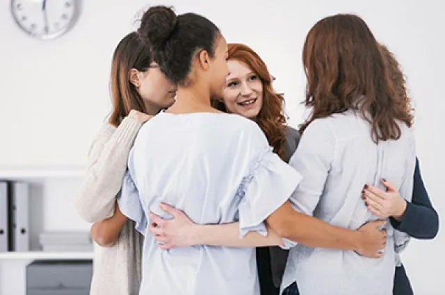 Women with issues supporting together during group therapy